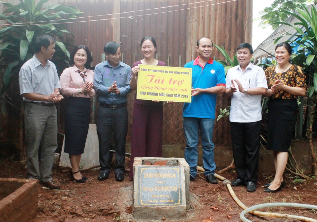 Lãnh đạo Quỹ Bảo trợ trẻ em tỉnh và đại diện Công ty TNHH sản xuất thương mại dịch vụ xuất nhập khẩu Đăng Phong trao bảng tài trợ công trình giếng nước cho Trường Mầm non Tân Lợi. 