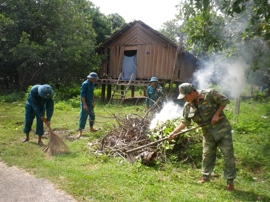 Cán bộ, chiến sĩ Ban Chỉ huy Quân sự huyện Buôn Đôn tham gia vệ sinh môi trường  ở buôn Đrang Phốk. 