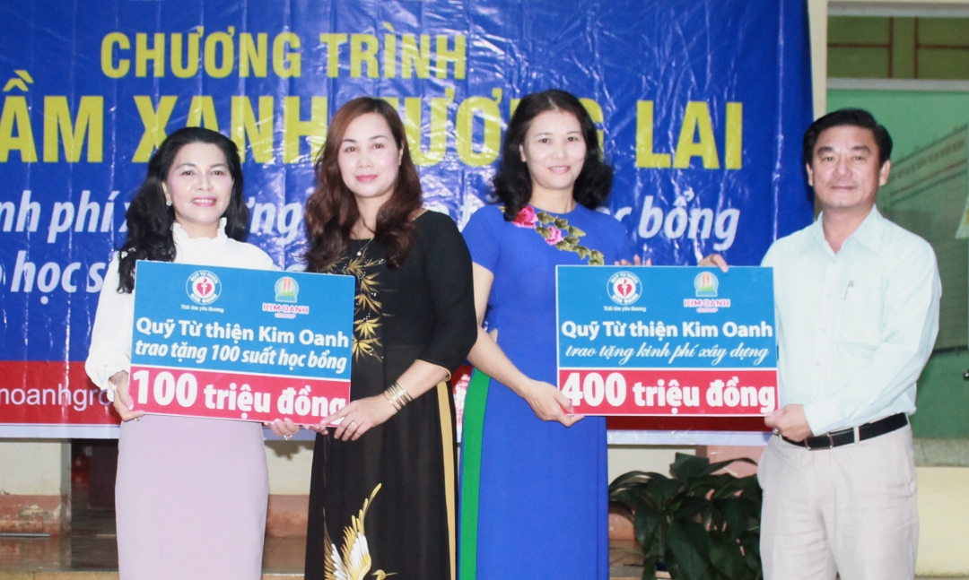 Đại diện Quỹ từ thiện Kim Oanh trao bảng tài trợ tượng trưng cho Ban Giám hiện Trường tiểu học Nguyễn Thị Định.