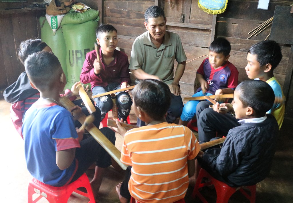 Nghệ nhân Y Gõ Niê dạy đánh chiêng cho các em nhỏ trong buôn.