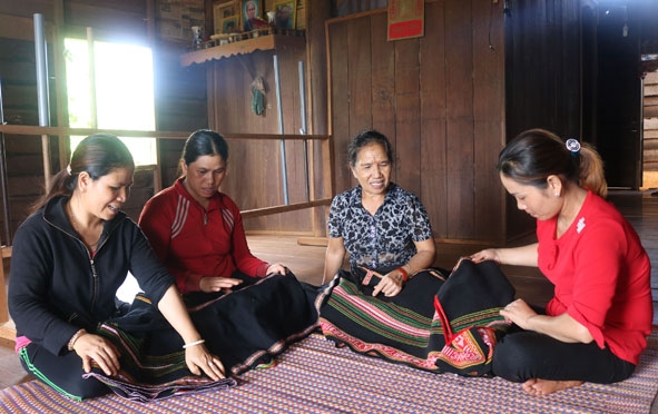 Các thành viên trong tổ dệt trao đổi kinh nghiệm. 