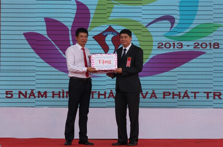 Giám đốc Sở GD-ĐT Phạm Đăng Khoa (bên phải) trao quà tặng thầy và trò Trường Đông Du nhân ngày khai giảng. 