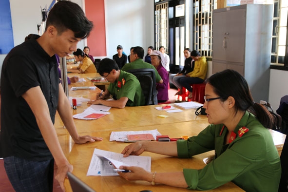 Cán bộ Đội Cảnh sát Quản lý hành chính về trật tự xã hội (Công an huyện Krông Năng) hướng dẫn người dân kê khai các 