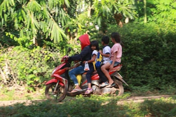 Phụ huynh chở “kẹp 4” đón con em đi học về. (Ảnh chụp đường giao thông trên địa bàn xã Ea Tu, TP. Buôn Ma Thuột). 