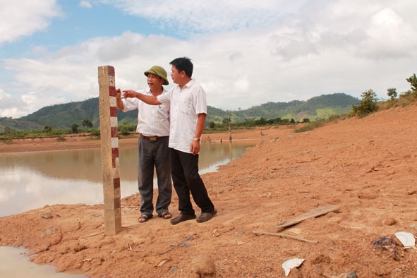 Cán bộ Phòng Nông nghiệp và Phát triển nông thôn huyện Ea Kar kiểm tra mực nước ở hồ chứa Ea Thu  (xã Cư Bông). 