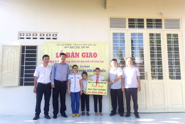 Lãnh đạo Quỹ BTTE tỉnh và đại diện chính quyền địa phương trao bảng tượng trưng tài trợ xây nhà cho mẹ con em Lục Thị Thắm trước ngôi nhà mới.