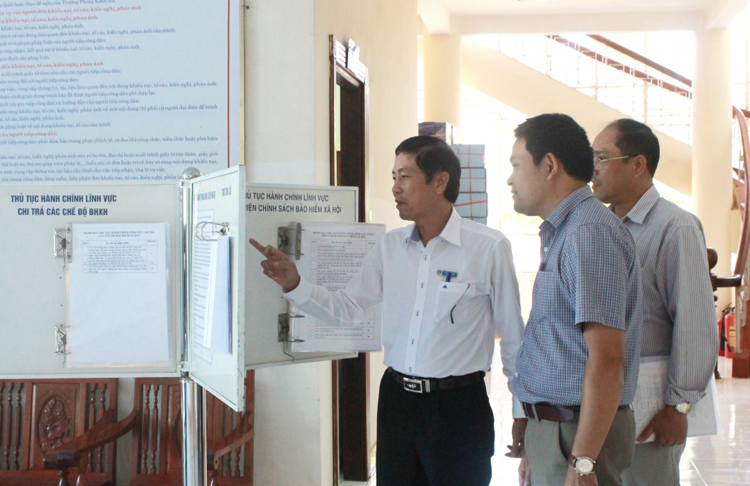 Thành viên Đoàn kiểm tra kiểm tra việc niêm yết công khai TTHC của BHXH tỉnh. 