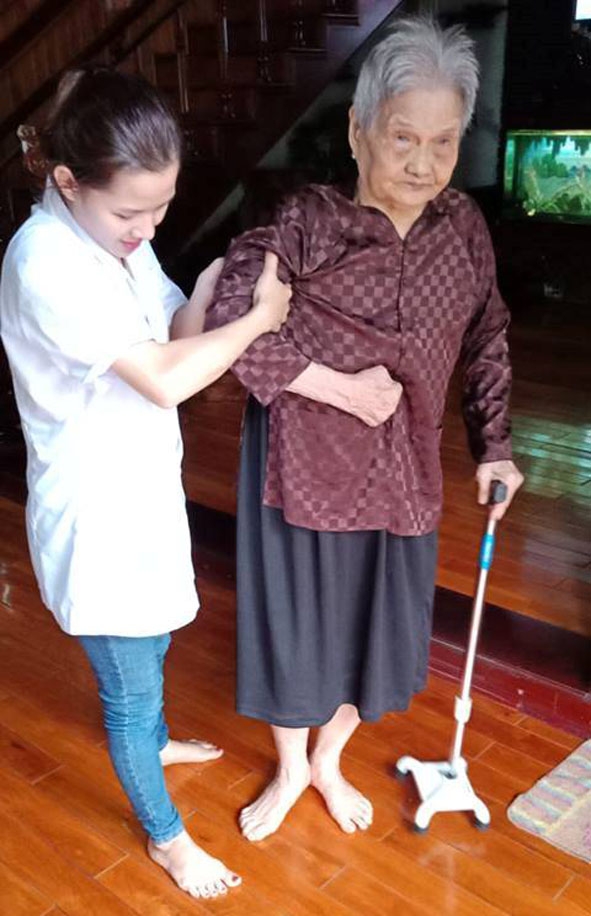 Nhân viên y tế đang chăm sóc sức khỏe cho bà Hợi tại nhà. Ảnh do Công ty Cổ phần Help Global cung cấp