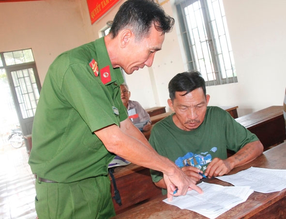 Trung tá Nguyễn Thanh Hải, Trưởng Công an phường Khánh Xuân hướng dẫn người dân ghi phiếu thu thập  thông tin dân cư.   