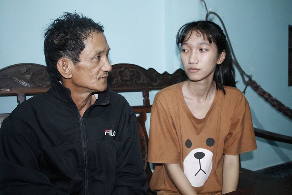 Bố con ông Lê Đình Nước thẫn thờ nhớ về người vợ đã khuất. 
