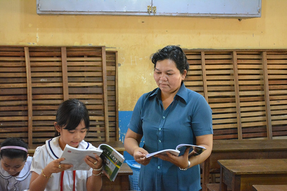 Cô H’Yok Ênuôl hướng dẫn học sinh đọc bài.  