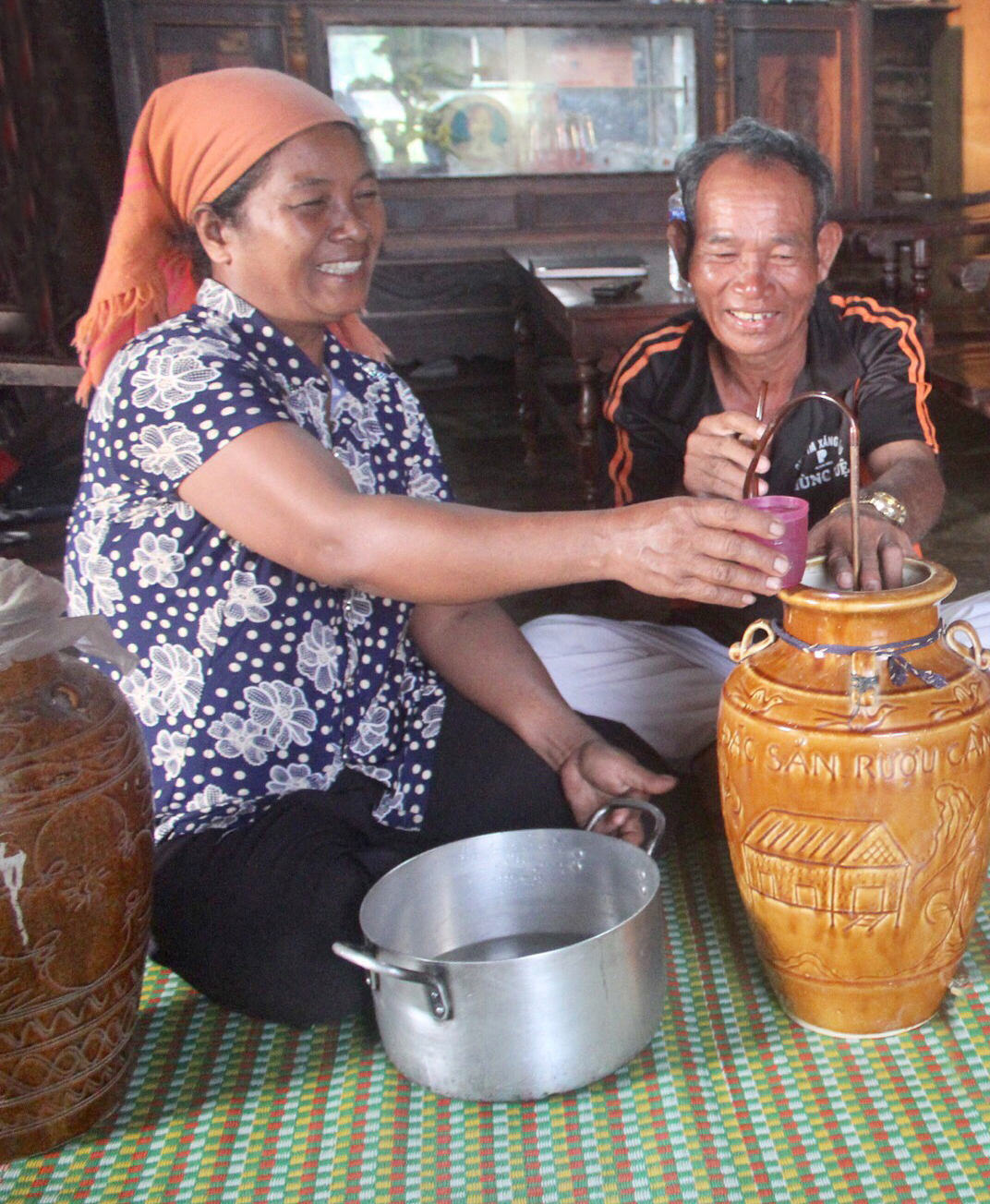 Bà H’Jang Pang Ting đón khách với ché rượu cần của người M’nông.  