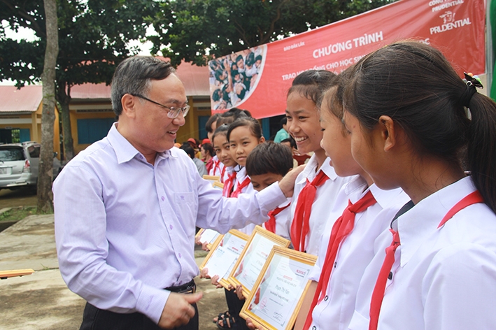 Tổng Biên tập Báo Đắk Lắk Nguyễn Văn Phú tặng quà động viên học sinh tại một trường học của huyện  Krông Bông trước thềm năm học mới. 