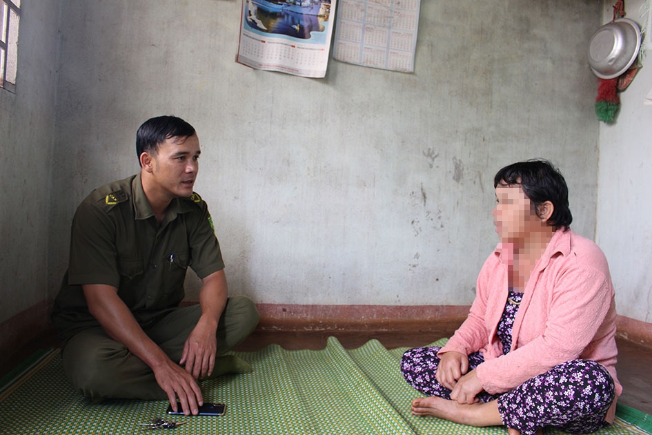 Trưởng Công an xã Chư Kbô Lê Tuấn Anh vận động người nhà đưa đối tượng đi cai nghiện ma túy. Ảnh: N. Quỳnh  (Đề nghị làm mờ mặt bà này)