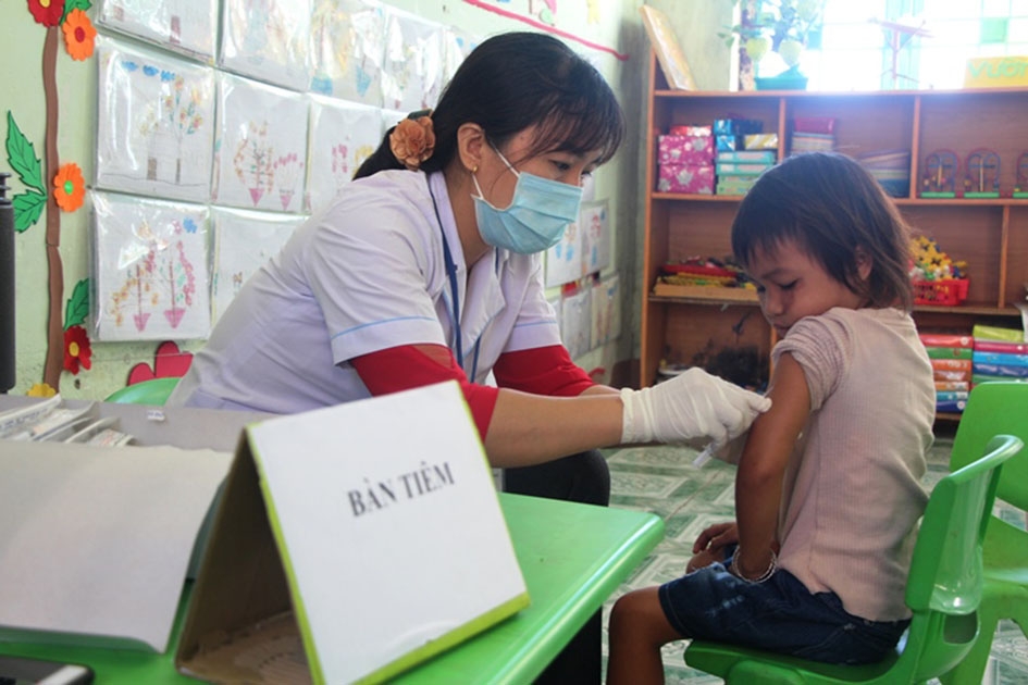 Cán bộ Trung tâm Y tế TP. Buôn Ma Thuột tiêm vắc xin ngừa sởi - rubella cho trẻ em thôn 7, xã Cư Êbur.
