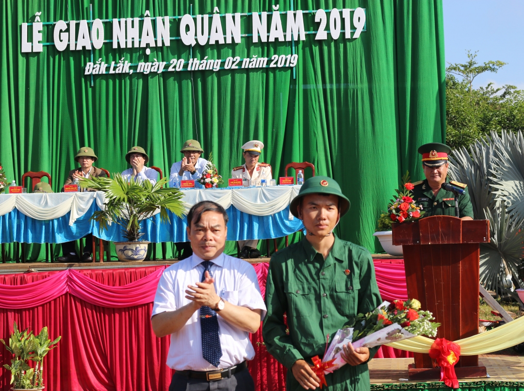 Phó Bí thư Huyện ủy, Chủ tịch UBND huyện Krông Pắc Đinh Xuân Diệu tặng hoa động viên tân binh trước lúc lên xe về đơn vị