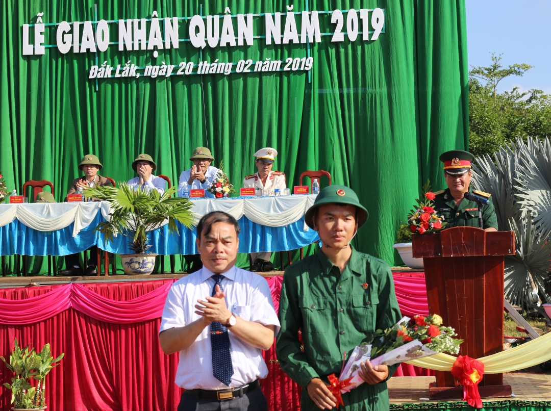 Phó Bí thư Huyện ủy, Chủ tịch UBND huyện Krông Pắc Đinh Xuân Diệu tặng hoa động viên tân binh trước lúc lên xe về đơn vị