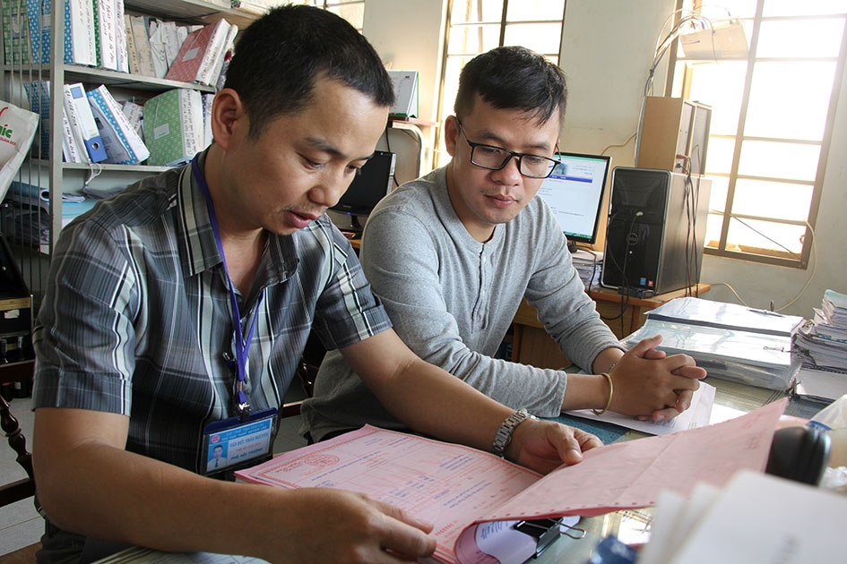 Cán bộ Chi cục Thuế huyện Lắk (trái) kiểm tra hóa đơn, chứng từ tại Công ty TNHH Xây dựng Thuận Thành. 