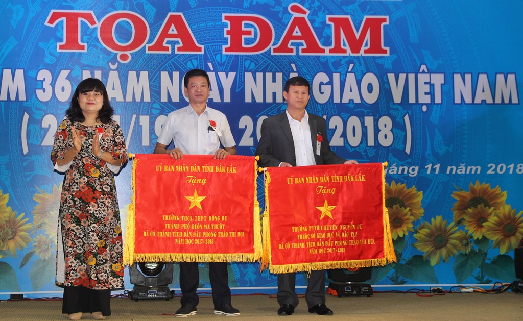 Phó Chủ tịch UBND tỉnh H’Yim Kđoh trao Cờ thi đua của UBND tỉnh tặng Trường Đông Du (đứng giữa) vì thành tích dẫn đầu phong trào thi đua năm học 2017-2018.