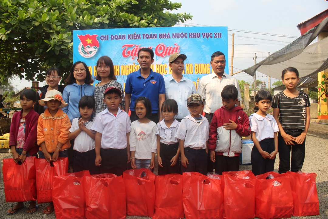 Đại diện huyện Đoàn Buôn Đôn và Chi đoàn Kiểm toán Nhà nước khu vực XII tặng quà cho học sinh nghèo xã Ea Nuôl (huyện Buôn Đôn).