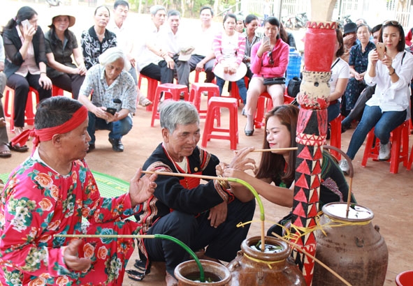 Nghi thức đeo vòng tay cầu an và cầu sức khỏe cho gia chủ trong Lễ dựng cây nêu cầu an ở buôn Ju, xã Ea Tu (TP. Buôn Ma Thuột).   Ảnh: T. Hồng