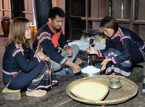  Chị H’Phiu Kbuôr (bên phải)   thực hiện công đoạn cơm  trộn men  để ủ  rượu cần. 