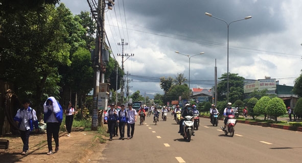 Học sinh đi bộ dàn hàng ngang dưới lòng đường Hùng Vương (thị trấn Quảng Phú,  huyện Cư M'gar). 