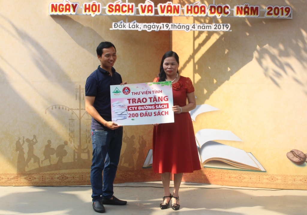 Bà Phạm Thị Kim, Giám đốc Thư viện tỉnh trao sách tặng Công ty Đường Sách Cà phê Buôn Ma Thuột.