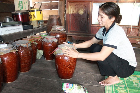 Chị H'Di làm sẵn rượu cần để bán cho khách.