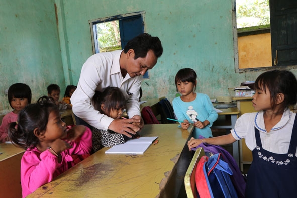 Giáo viên Trường Tiểu học Đinh Núp (xã Ea Yiêng, huyện Krông Pắc) hướng dẫn học sinh viết chữ.