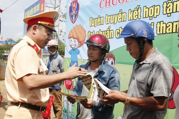 Trung tá Huỳnh Thanh Bình, Phó Trưởng Phòng CSGT (Công an tỉnh) tuyên truyền về quy định đội mũ bảo hiểm  cho người dân.  