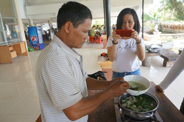 Anh  Y Danh Niê trổ tài nấu “Canh bồi măng lửa rau ngót rừng”  cho khách du lịch.   