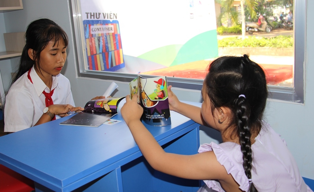 Các em học sinh đọc sách tại thư viện mới