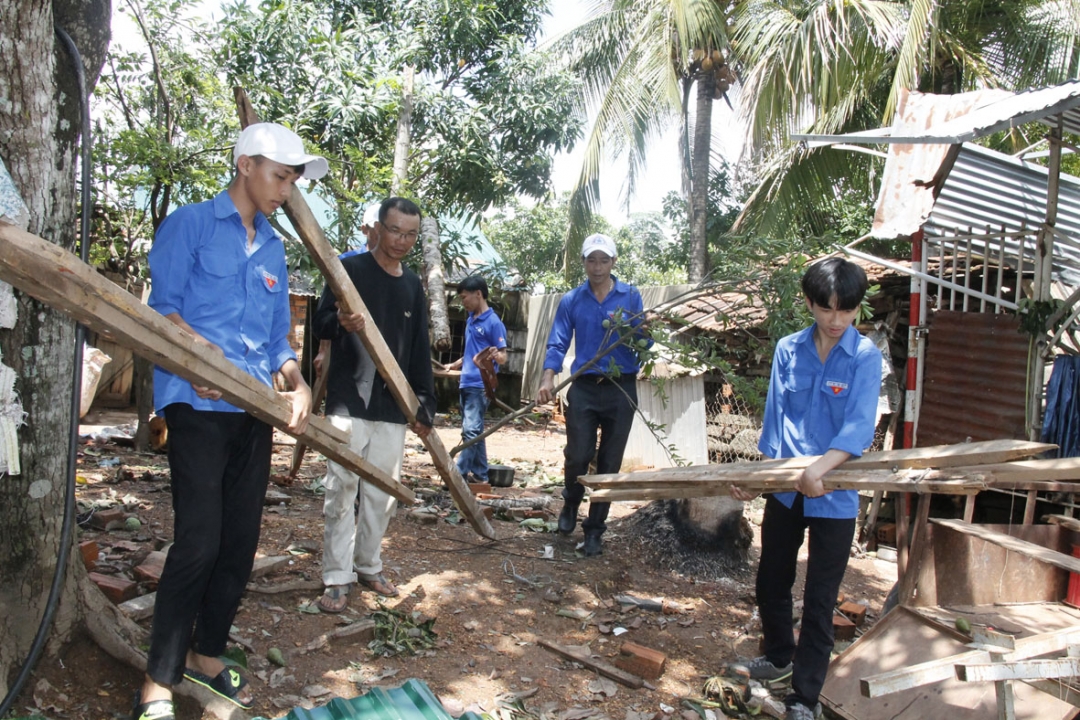 Đoàn viên, thanh niên xã Dray Sáp giúp người dân dọn dẹp nhà cửa bị sập, đổ do mưa lốc. 