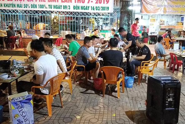 Một nhóm người sử dụng thùng karaoke di động ngồi ăn uống, hát hò trên vỉa hè đường phố Buôn Ma Thuột.