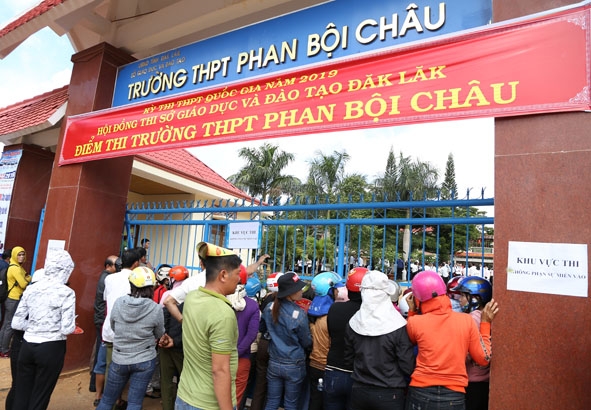 Phụ huynh đợi con tại điểm thi Trường THPT Phan Bội Châu (thị trấn Krông Năng).  Ảnh: T.Hùng.