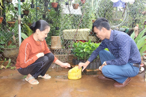Cán bộ Trạm Y tế xã Pơng Drang, huyện Krông Búk (bên phải) hướng dẫn người dân cách vệ sinh môi trường, diệt lăng quăng.  Ảnh: N.Quỳnh