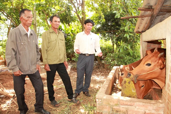 Ông Y Ruê Byă (giữa), Trưởng Ban công tác Mặt trận trao đổi  cách phát triển kinh tế của gia đình. 