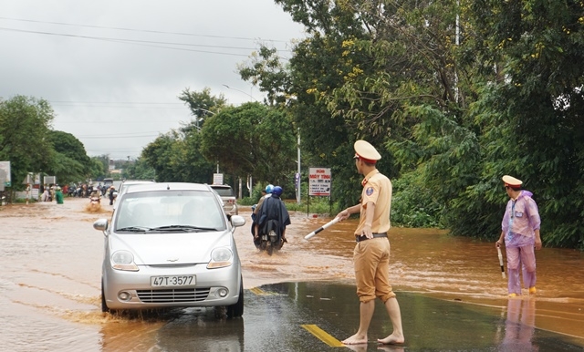 Lực lượng cảnh sát giao thông điều tiết phương tiện qua đoạn nước ngập.
