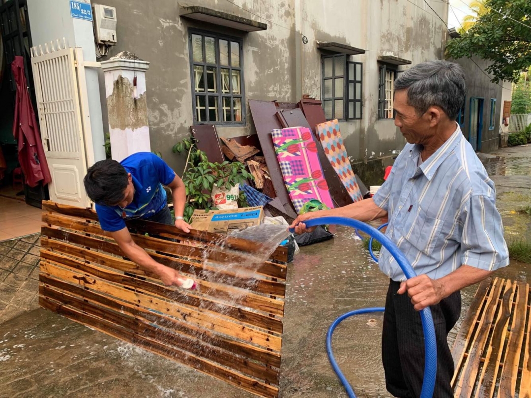 Ông Lê Quang Xin (đường Tiên Hoàng, Tổ dân phố 6A, P.Tự An) cùng con rể cọ rửa liếp giường. Ông Xin cho hay, nước ngập vào nhà ông đến 1,2 m khi cả nhà đều đi làm khiến mọi đồ đạc của gia đình đều bị hư hỏng, thiệt hại ước tính 70 triệu đồng