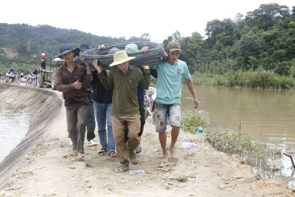 Người dân vận chuyển vật liệu làm hàng rào ngăn nước cứu đê.  