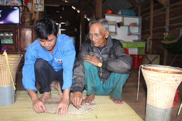 Ông Y Bok Mlô đang truyền nghề đan lát cho thanh niên ở địa phương.