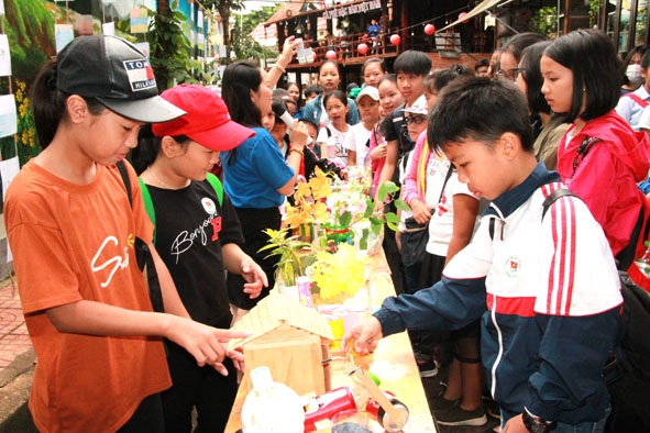 Các em thiếu nhi tìm hiểu những sản phẩm được tái chế từ đồ nhựa, lon nhôm...  tại Đường sách Cà phê Buôn Ma Thuột. 