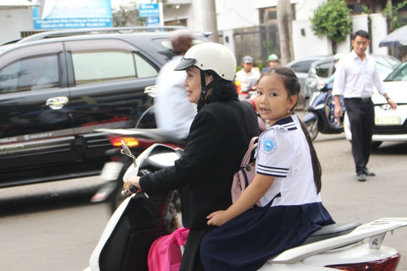 Một phụ huynh không đội mũ bảo hiểm cho trẻ khi tham gia giao thông. 