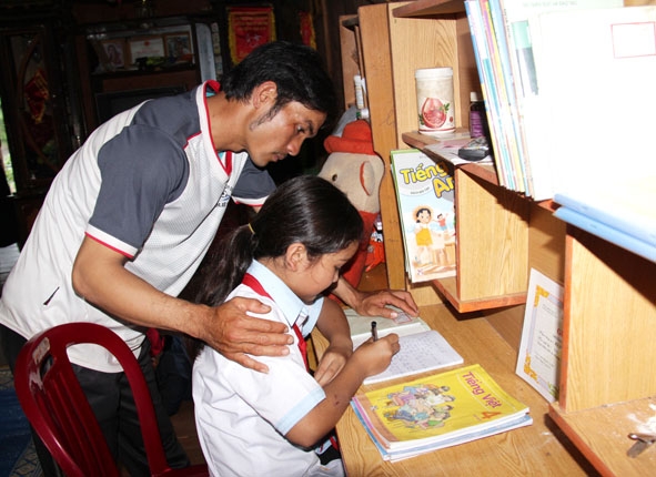 Anh Kpă Y Hồng hướng dẫn con gái học bài.  