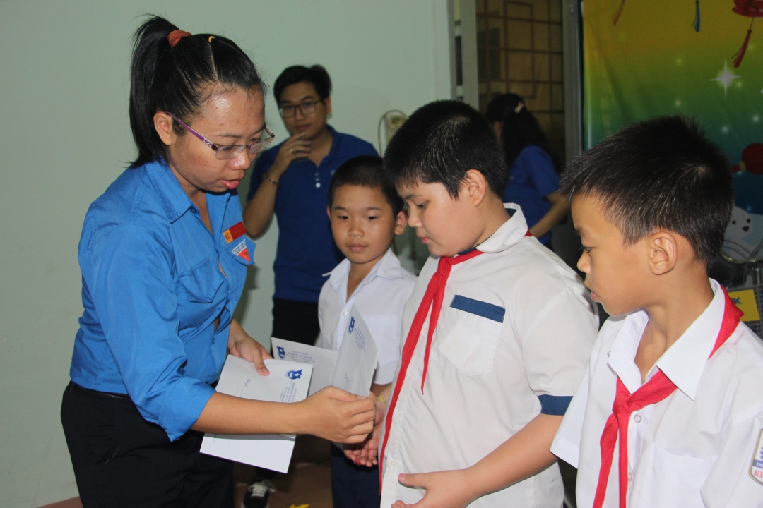 Đại diện Hội đồng Đội TP. Buôn Ma Thuột trao học bổng cho các em học sinh.