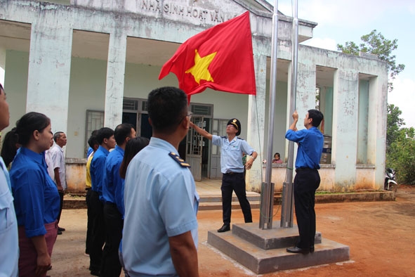 Đoàn viên Cụm thi đua số 7 và người dân buôn Bu Prăng I tổ chức lễ thượng cờ.   