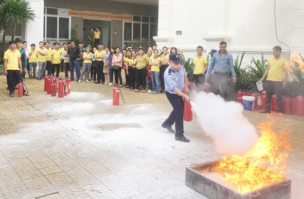 Cán bộ, viên chức Bưu điện tỉnh thực hành sử dụng bình chữa cháy.   Ảnh: H. Hải