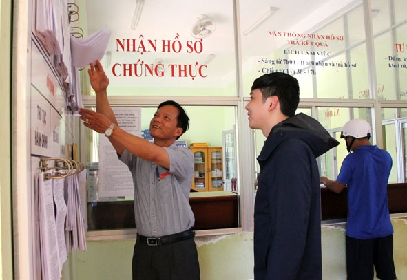 Lãnh đạo UBND phường Tân Tiến hướng dẫn người dân tìm hiểu quy trình, hồ sơ giải quyết thủ tục hành chính. 
