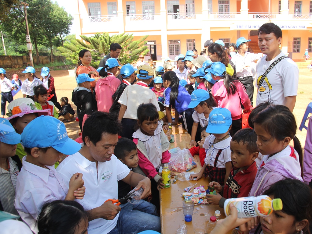 Tình nguyện viên hướng dẫn các em học sinh tái chế chai nhựa